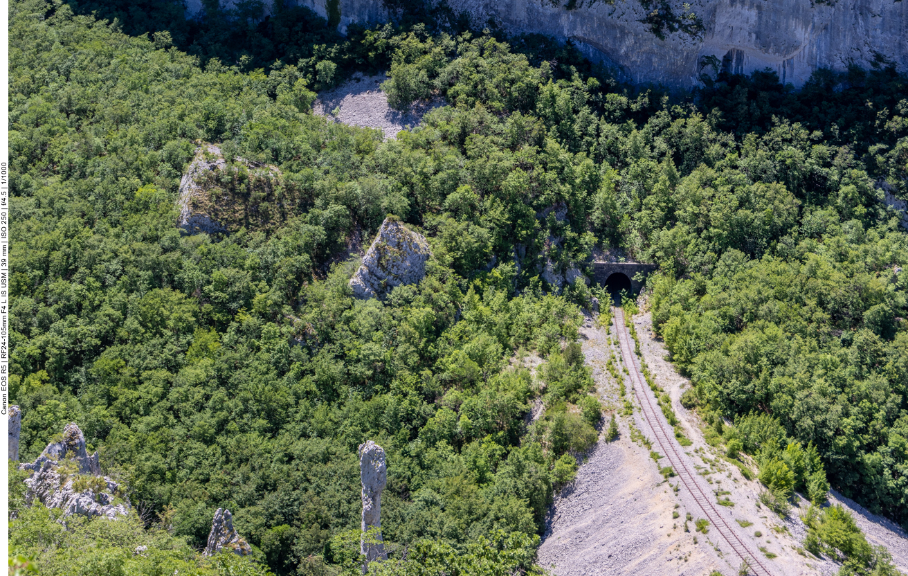 Einsame Kalksteins&auml;ule und Eisenbahnstrecke im Tal