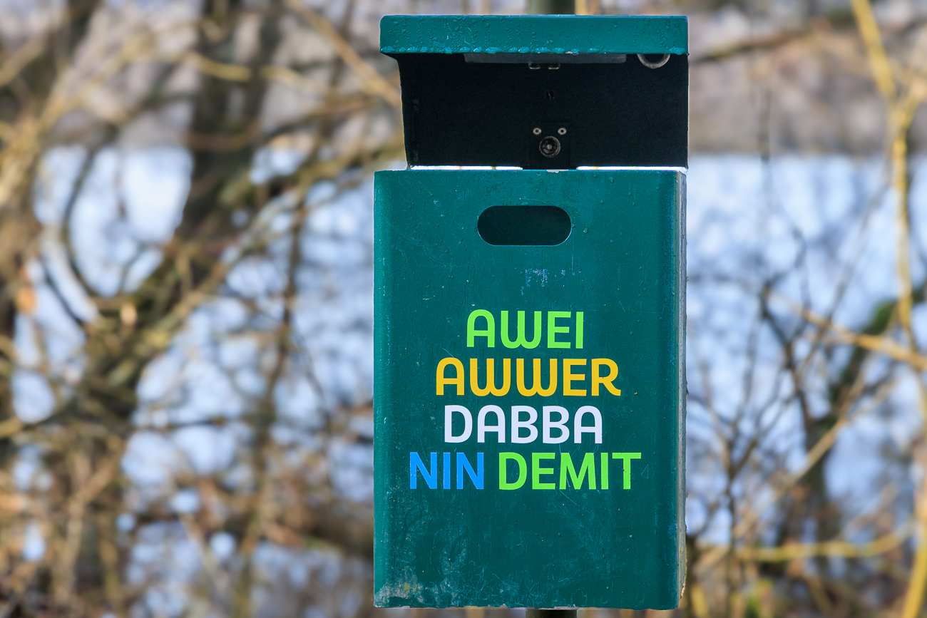 M&uuml;lleimer mit lustiger Beschriftung stehen alle paar hundert Meter bereit